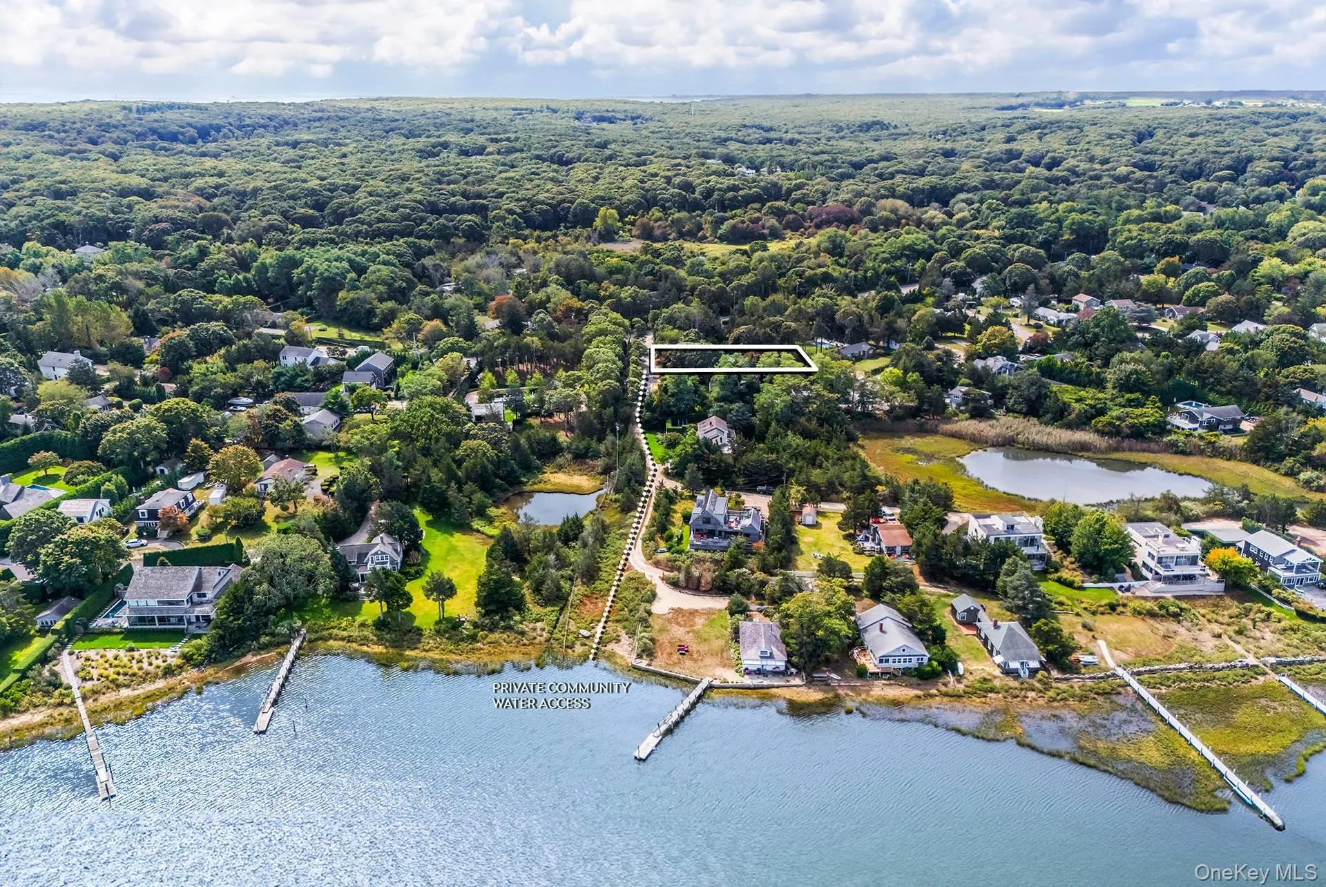 Aerial perspective of suburban area featuring a large body of water and property parcel outlined Aerial perspective of suburban area featuring a large body of water and property parcel outlined