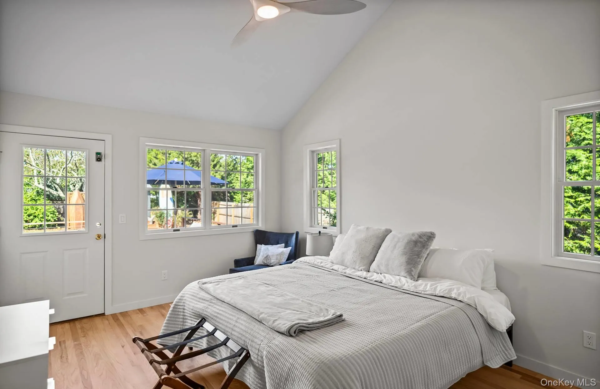Bedroom with light wood-style floors, high vaulted ceiling, and a ceiling fan Bedroom with light wood-style floors, high vaulted ceiling, and a ceiling fan