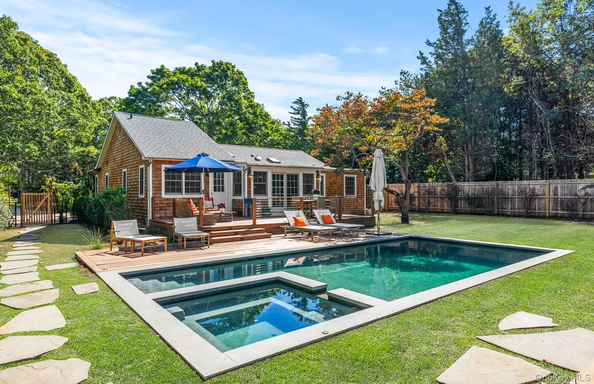 View of swimming pool with a patio area, a fenced backyard, a pool with connected hot tub, and view of scattered trees View of swimming pool with a patio area, a fenced backyard, a pool with connected hot tub, and view of scattered trees