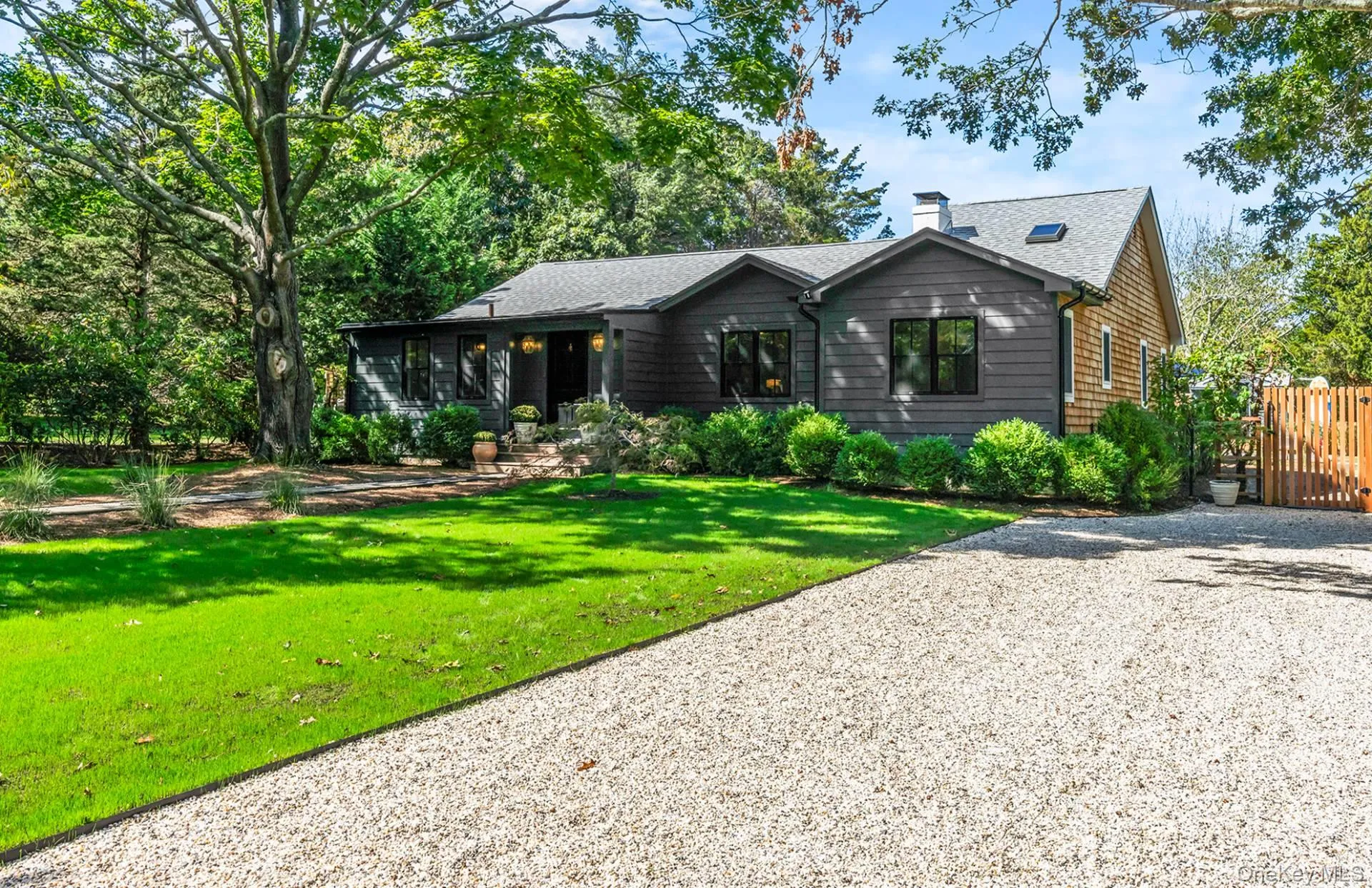 View of front of house featuring a chimney, roof with shingles, and gravel driveway View of front of house featuring a chimney, roof with shingles, and gravel driveway