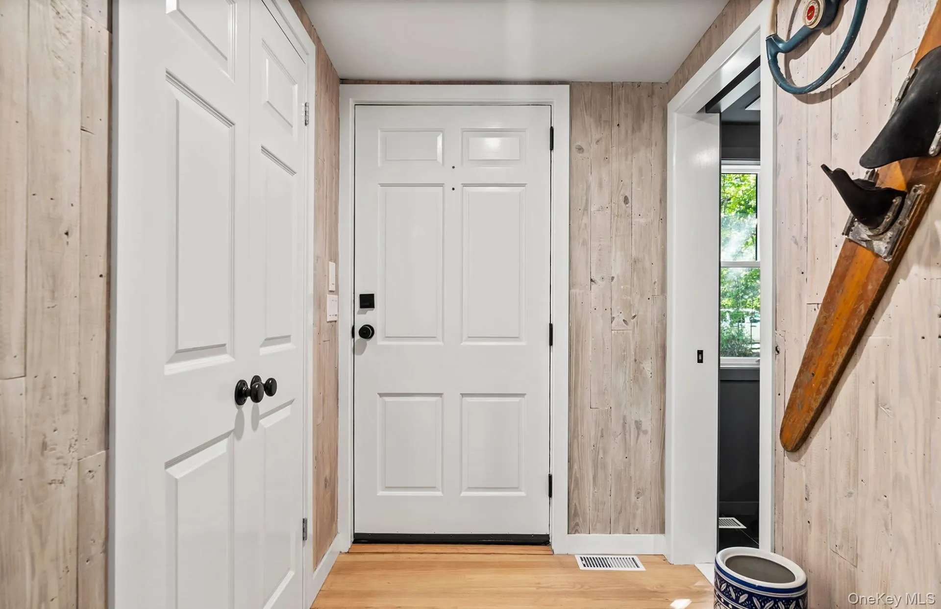 Doorway to outside with wooden walls and wood finished floors Doorway to outside with wooden walls and wood finished floors