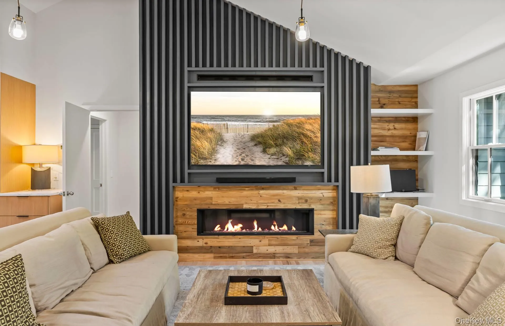Living area with lofted ceiling, a lit fireplace, and plenty of natural light Living area with lofted ceiling, a lit fireplace, and plenty of natural light