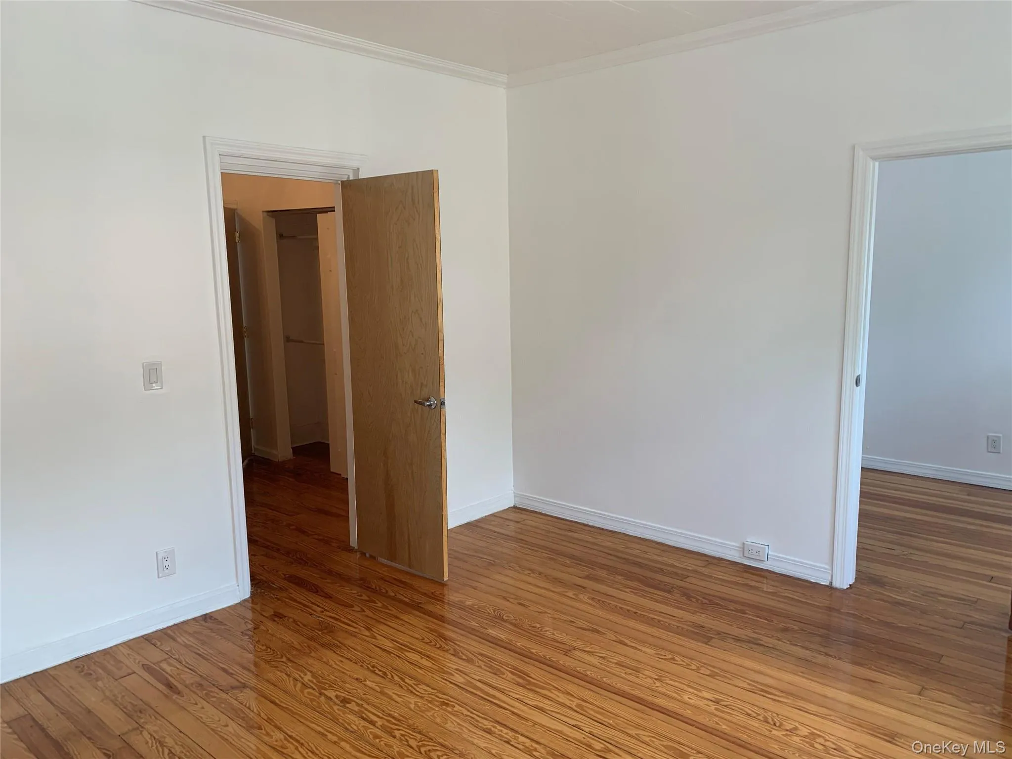 Spare room with wood finished floors and ornamental molding Spare room with wood finished floors and ornamental molding