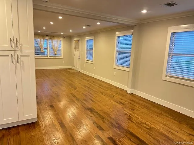 Spare room featuring dark wood finished floors, recessed lighting, and ornamental molding Spare room featuring dark wood finished floors, recessed lighting, and ornamental molding