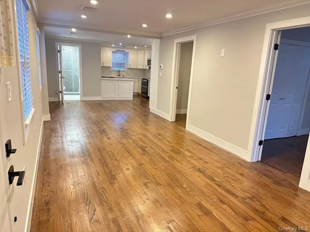 Unfurnished living room with wood finished floors, recessed lighting, and ornamental molding Unfurnished living room with wood finished floors, recessed lighting, and ornamental molding