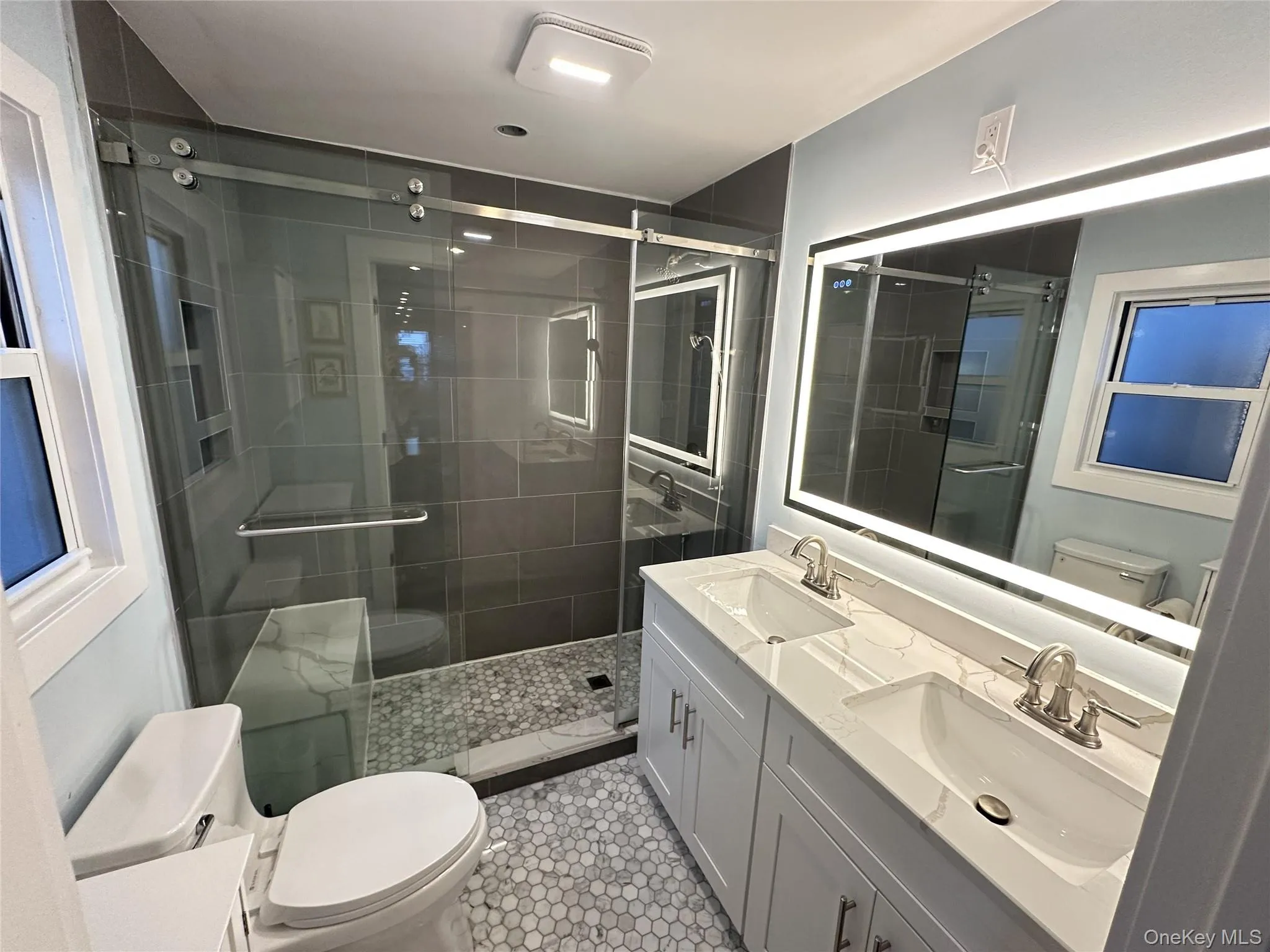 Bathroom with a stall shower, double vanity, and light tile patterned floors Bathroom with a stall shower, double vanity, and light tile patterned floors