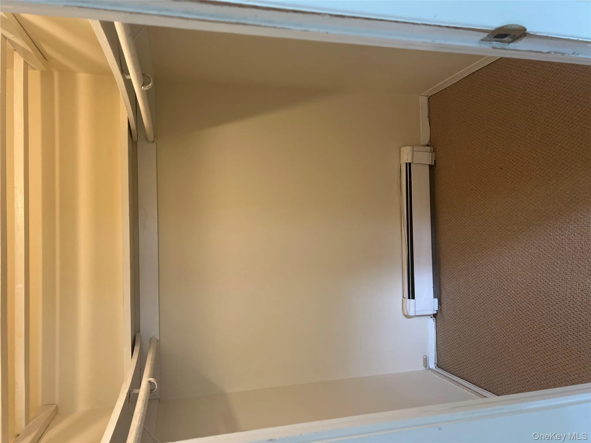 Walk in closet with carpet floors and baseboard heating Walk in closet with carpet floors and baseboard heating