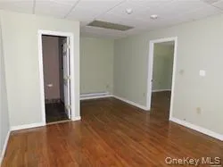 Empty room featuring a paneled ceiling and dark wood-style floors Empty room featuring a paneled ceiling and dark wood-style floors