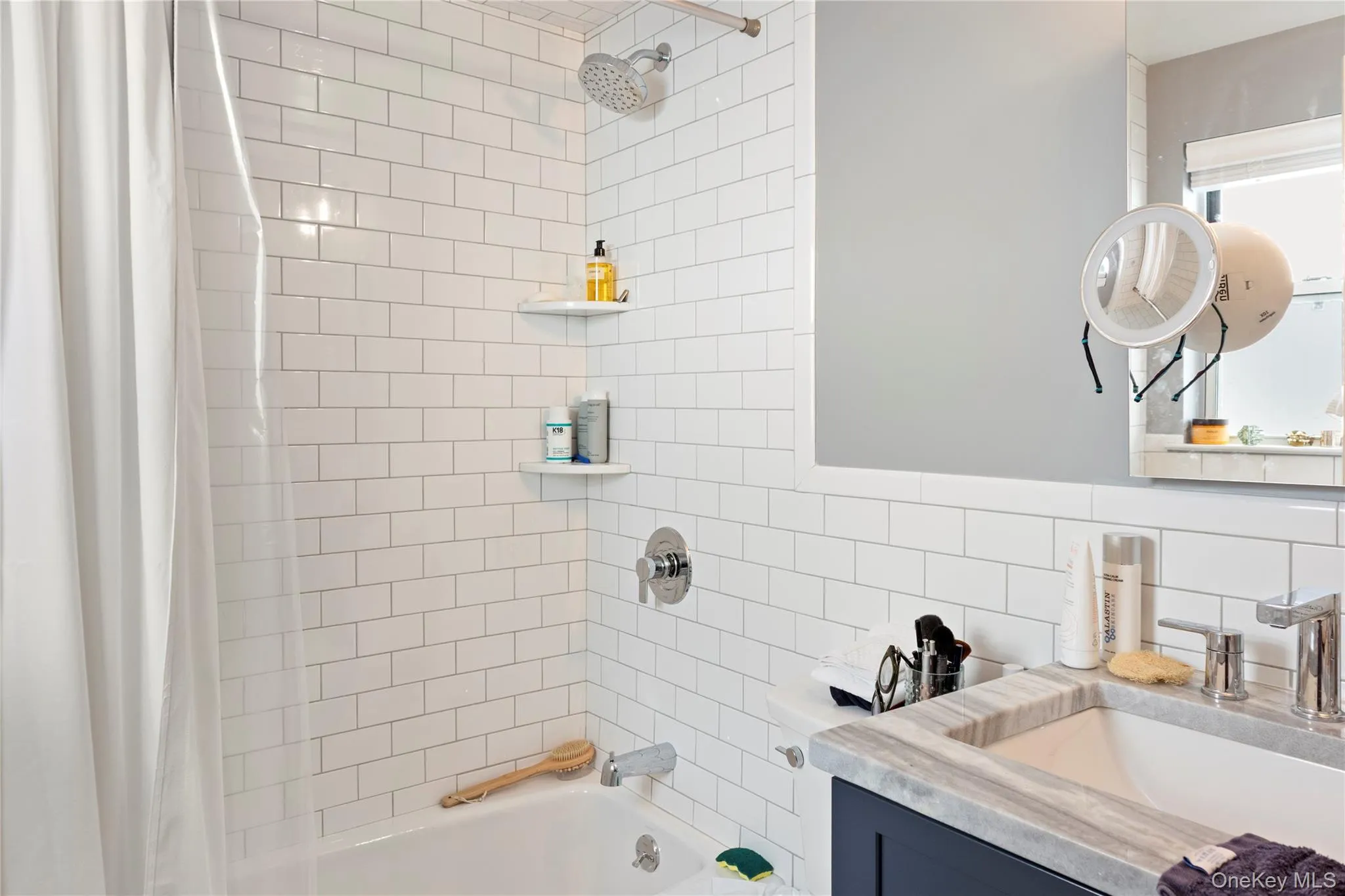 Full bath with shower / tub combo with curtain, vanity, and decorative backsplash Full bath with shower / tub combo with curtain, vanity, and decorative backsplash