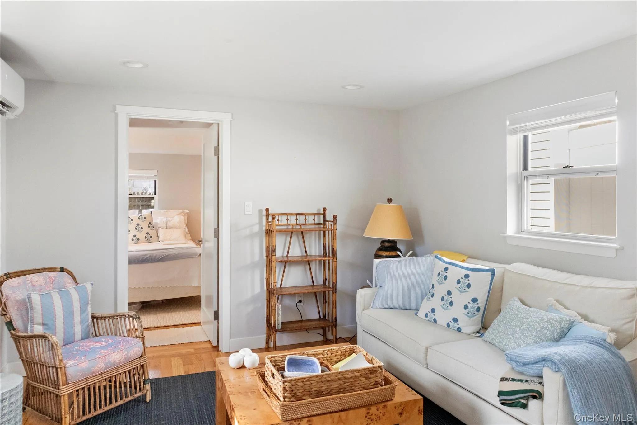Living area with wood finished floors, recessed lighting, and an AC wall unit Living area with wood finished floors, recessed lighting, and an AC wall unit