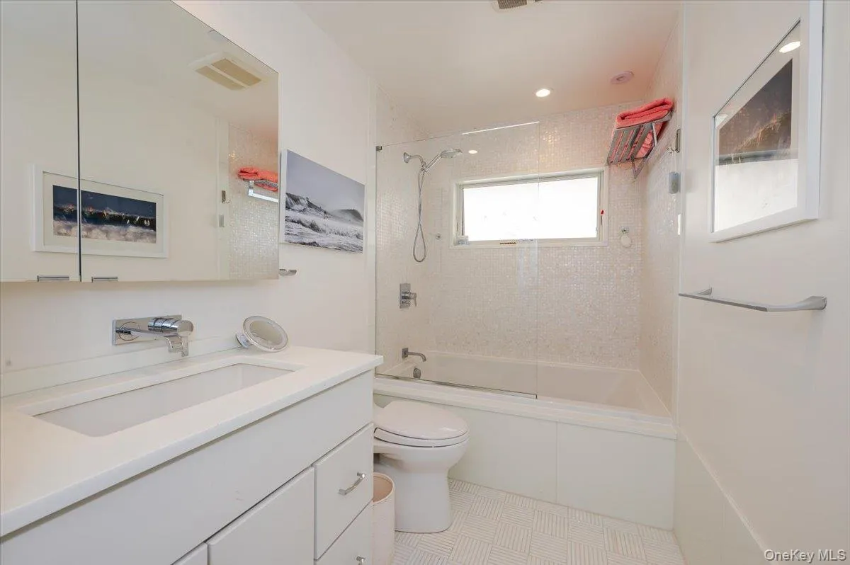 Bathroom featuring vanity, washtub / shower combination, and light tile patterned flooring Bathroom featuring vanity, washtub / shower combination, and light tile patterned flooring