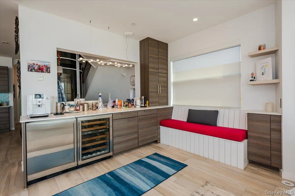 Indoor bar with light wood-type flooring, recessed lighting, open shelves, wine cooler, and modern cabinets Indoor bar with light wood-type flooring, recessed lighting, open shelves, wine cooler, and modern cabinets