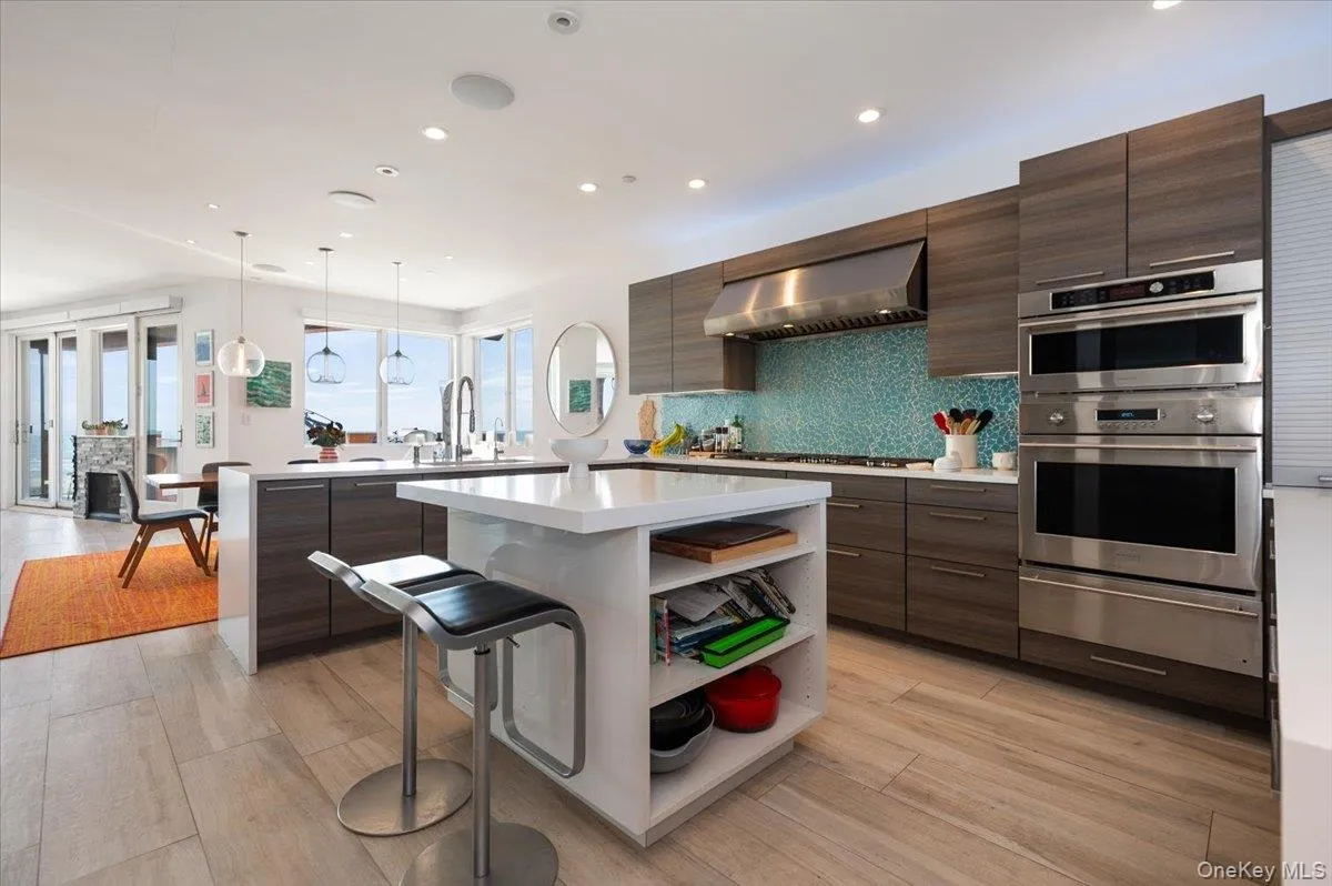 Kitchen with a kitchen bar, modern cabinets, dark brown cabinetry, and recessed lighting Kitchen with a kitchen bar, modern cabinets, dark brown cabinetry, and recessed lighting