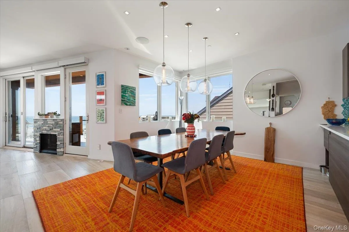 Dining room featuring light wood-style floors, recessed lighting, and a fireplace Dining room featuring light wood-style floors, recessed lighting, and a fireplace
