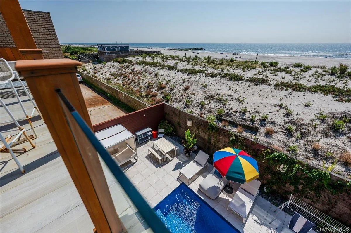View of swimming pool featuring view of water and beach View of swimming pool featuring view of water and beach