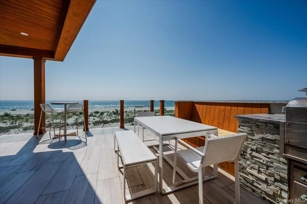 View of patio featuring outdoor dining space, view of water and beach, and area for grilling View of patio featuring outdoor dining space, view of water and beach, and area for grilling