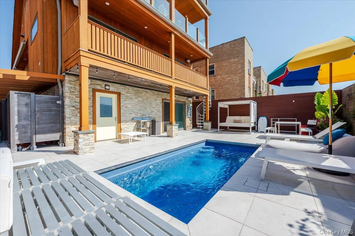 Outdoor pool featuring a patio area, a balcony, stairway, and an outdoor living space Outdoor pool featuring a patio area, a balcony, stairway, and an outdoor living space