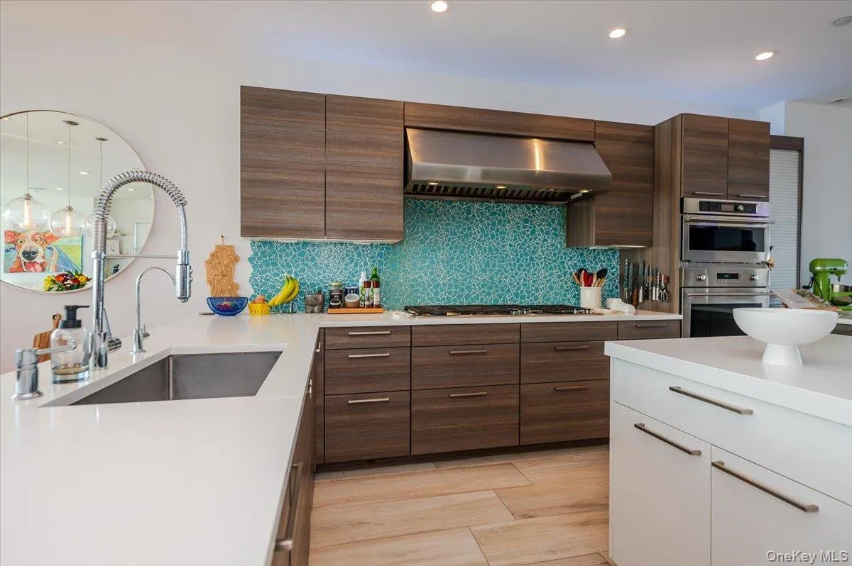 Kitchen with dark brown cabinetry, wall chimney range hood, white cabinets, recessed lighting, and backsplash Kitchen with dark brown cabinetry, wall chimney range hood, white cabinets, recessed lighting, and backsplash