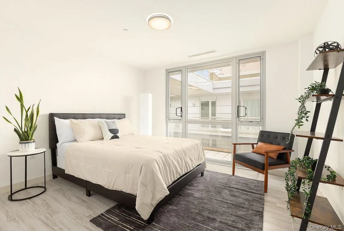 Bedroom with expansive windows and light wood finished floors Bedroom with expansive windows and light wood finished floors