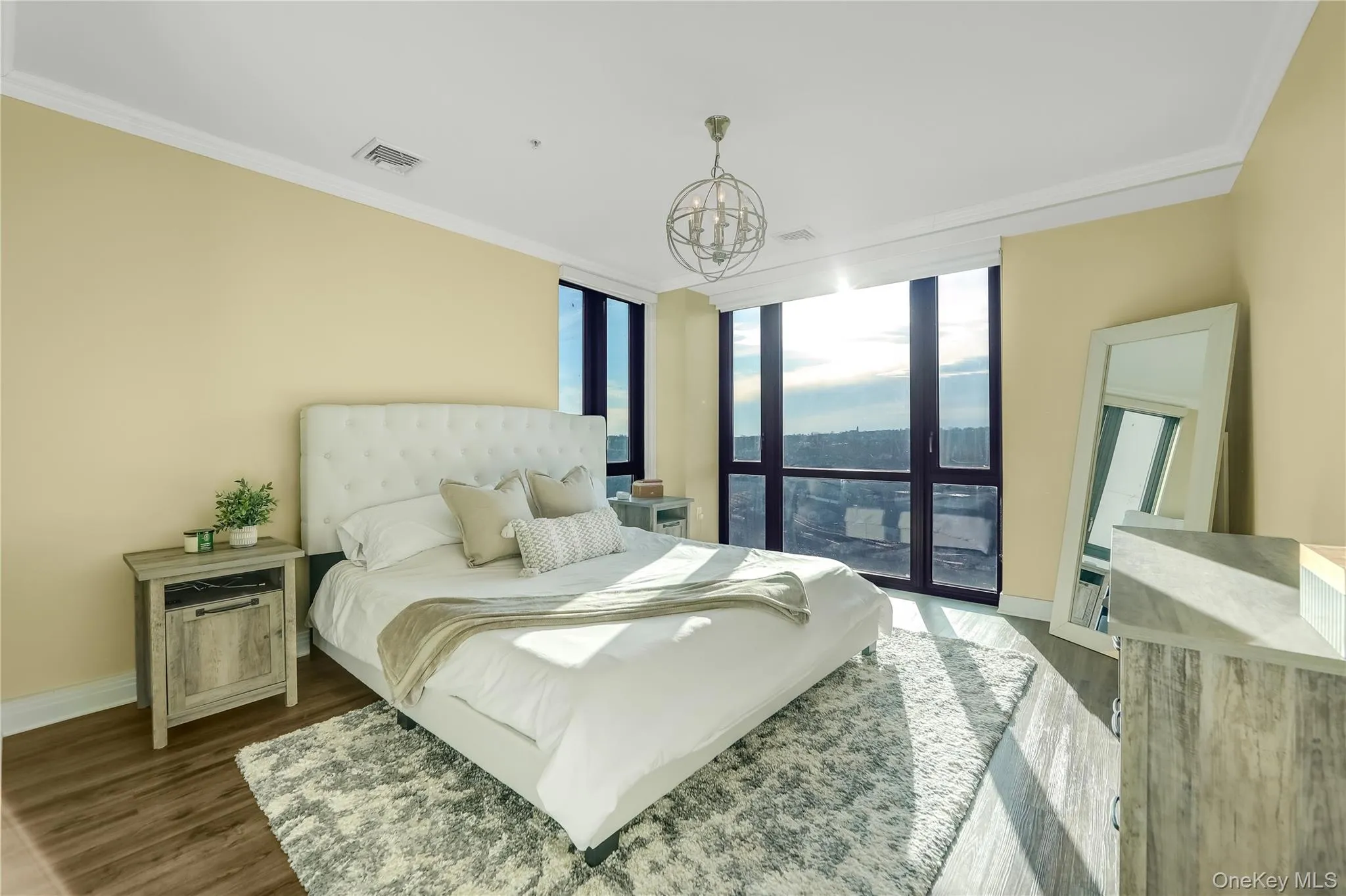 Bedroom featuring expansive windows, wood finished floors, ornamental molding, and access to outside Bedroom featuring expansive windows, wood finished floors, ornamental molding, and access to outside
