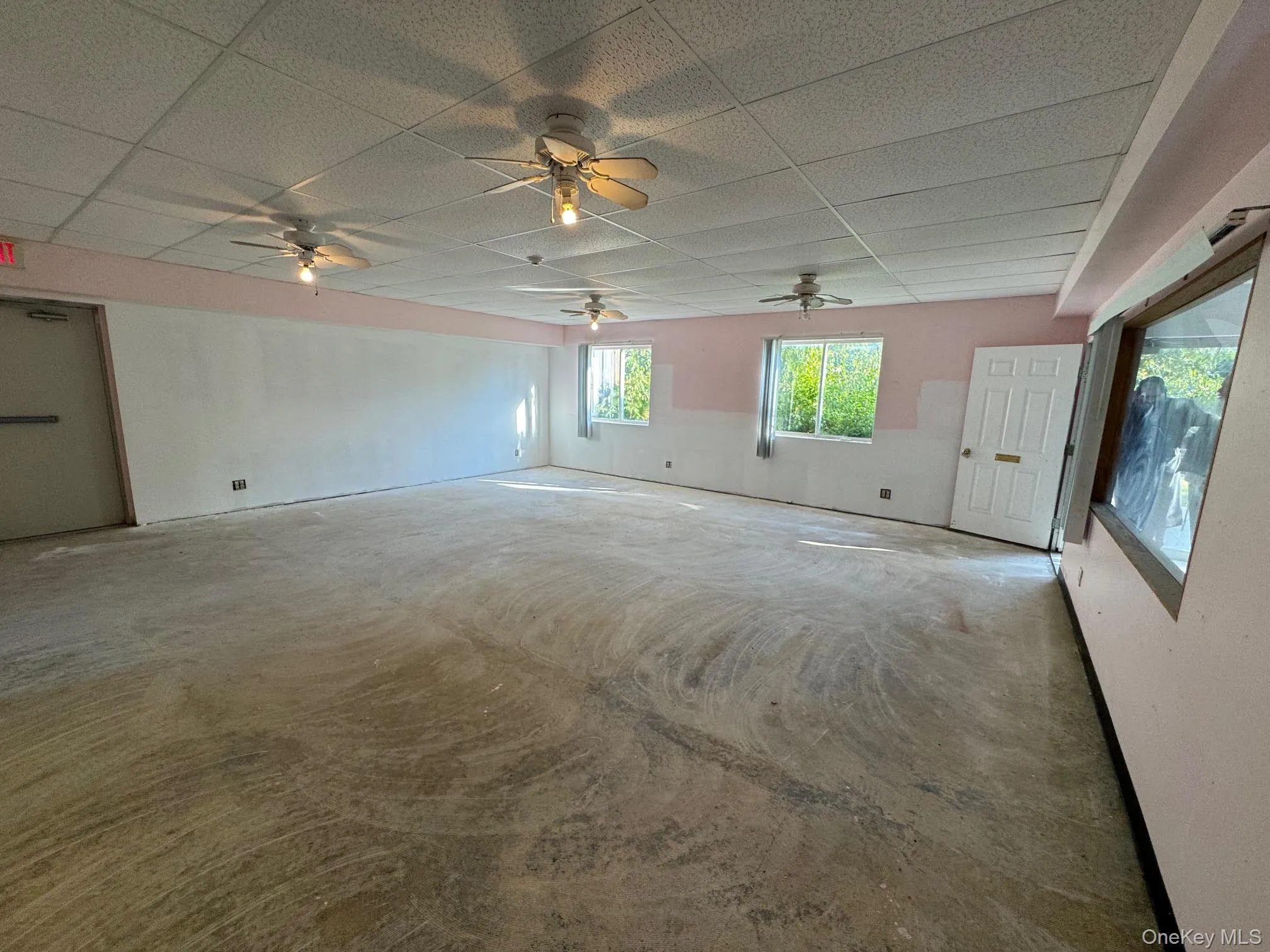 Open space with windows on ground floor with commercial concrete flooring. Open space with windows on ground floor with commercial concrete flooring.