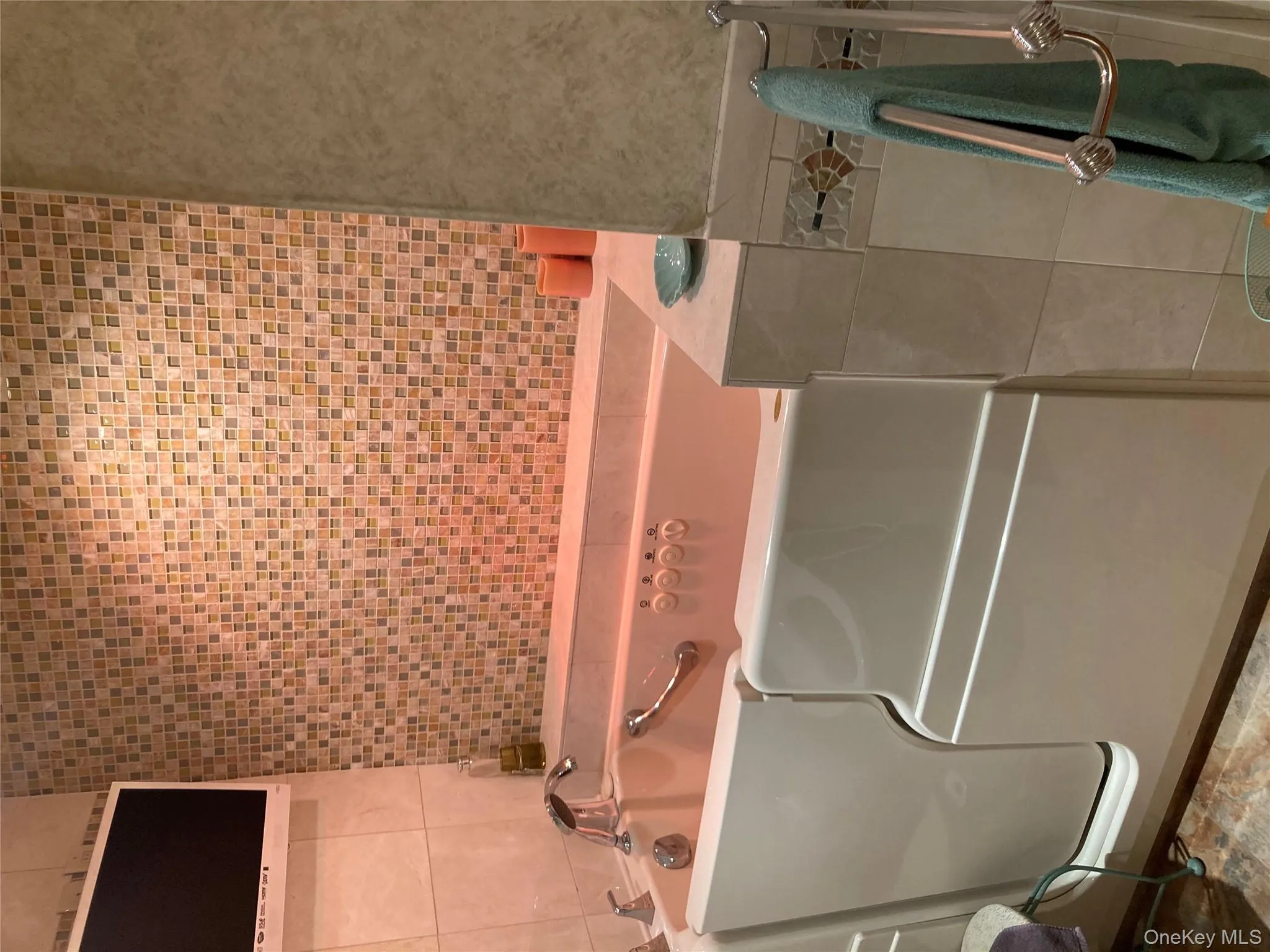 Bathroom featuring a garden tub and tile walls Bathroom featuring a garden tub and tile walls