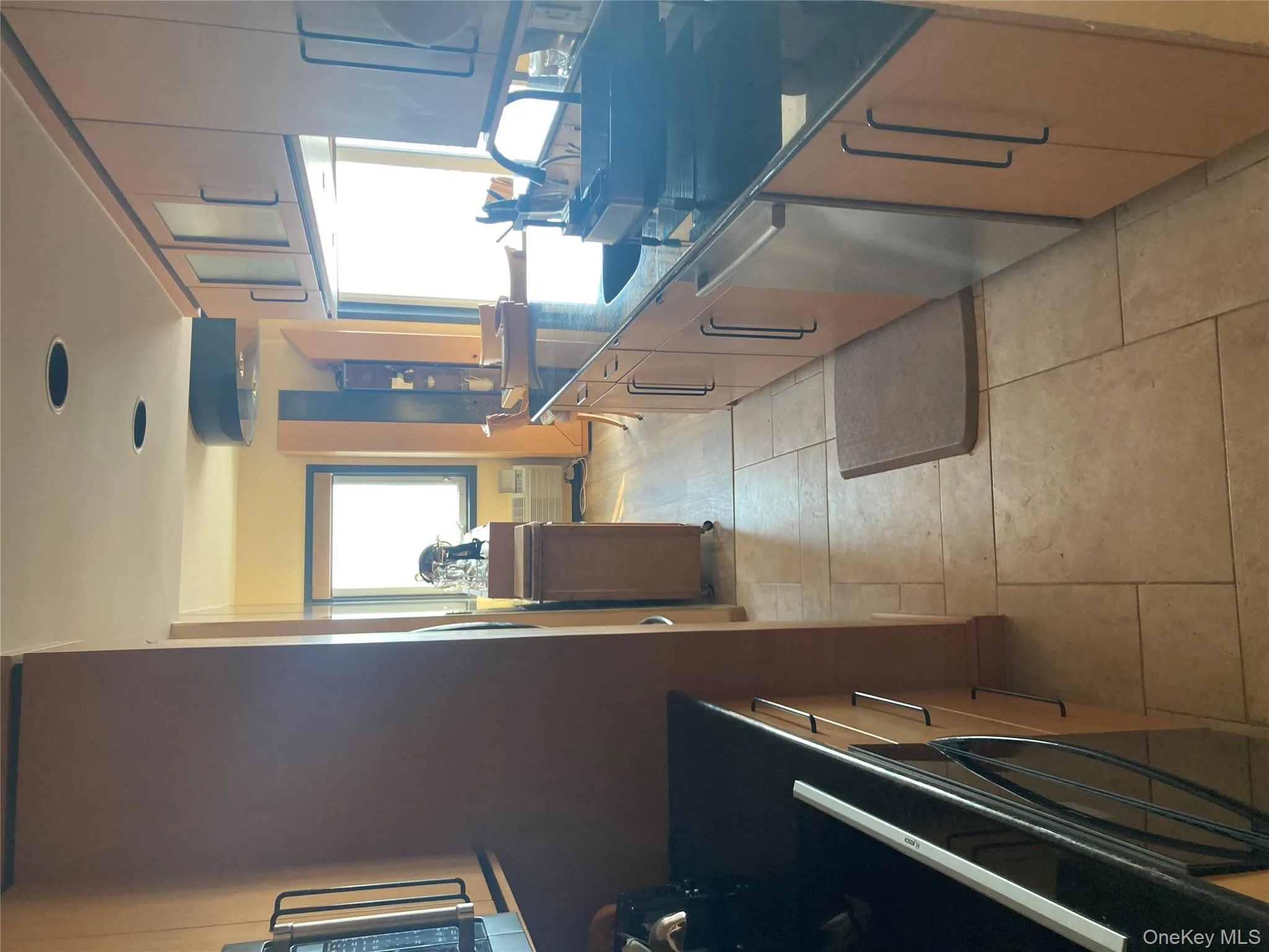 Kitchen featuring stainless steel dishwasher, dark stone counters, oven, and light tile patterned floors Kitchen featuring stainless steel dishwasher, dark stone counters, oven, and light tile patterned floors