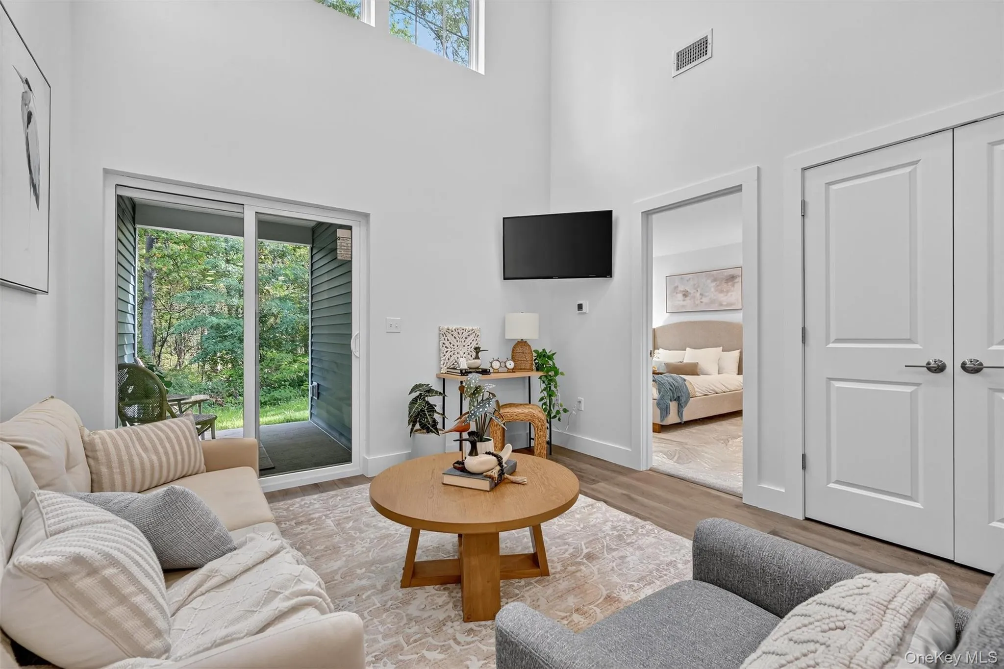 Living room with a towering ceiling and wood finished floors Living room with a towering ceiling and wood finished floors