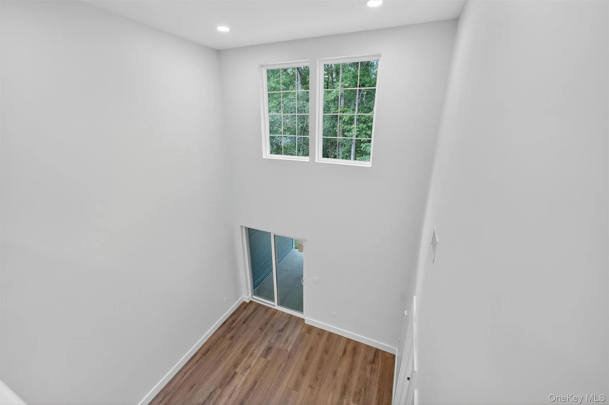 Empty room with wood finished floors and recessed lighting Empty room with wood finished floors and recessed lighting