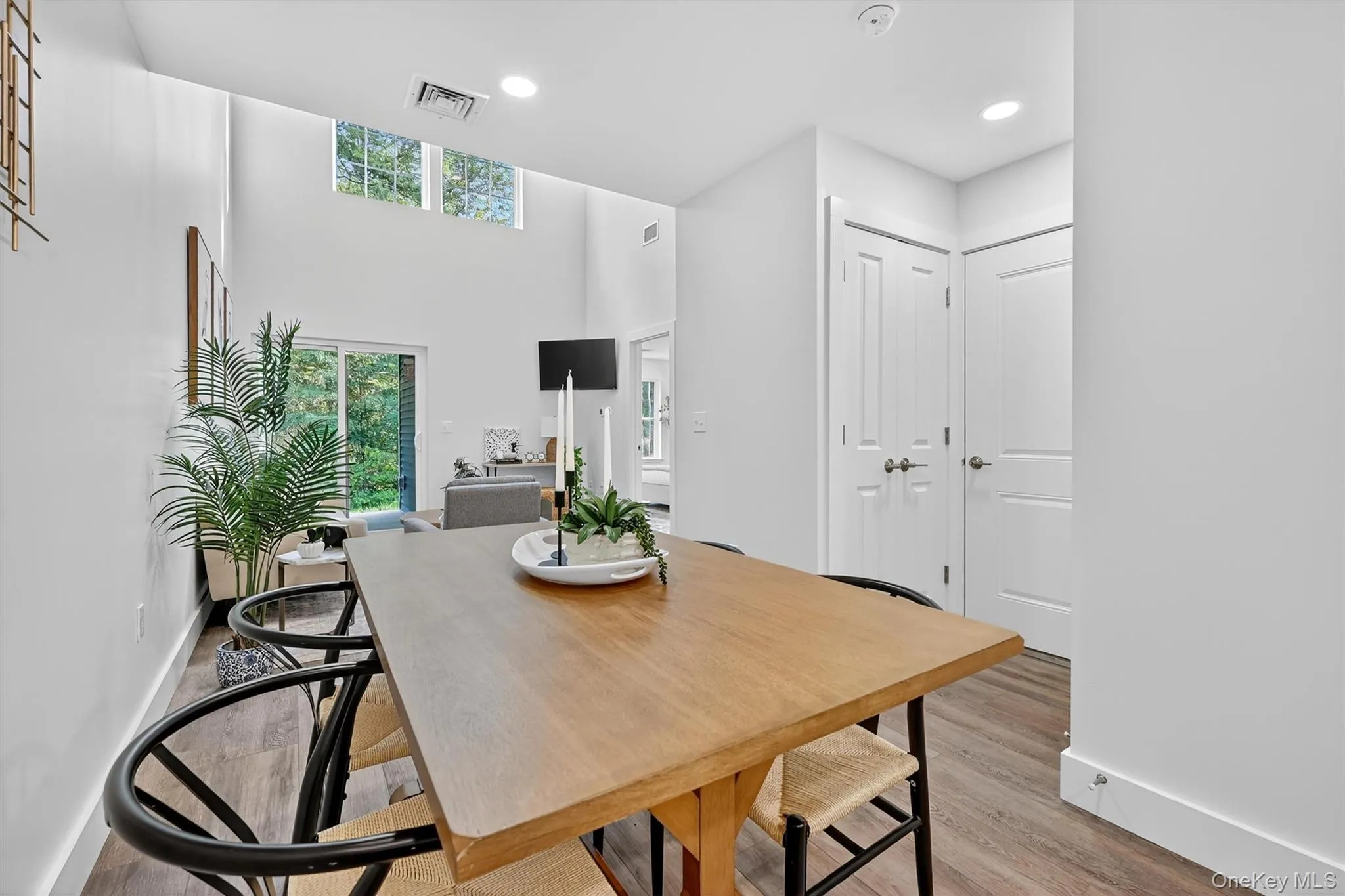 Dining room with wood finished floors, recessed lighting, and a high ceiling Dining room with wood finished floors, recessed lighting, and a high ceiling