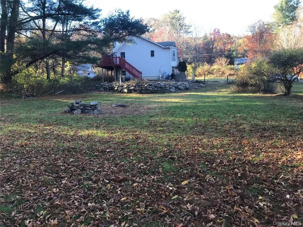 View of green lawn featuring stairway and a wooden deck View of green lawn featuring stairway and a wooden deck