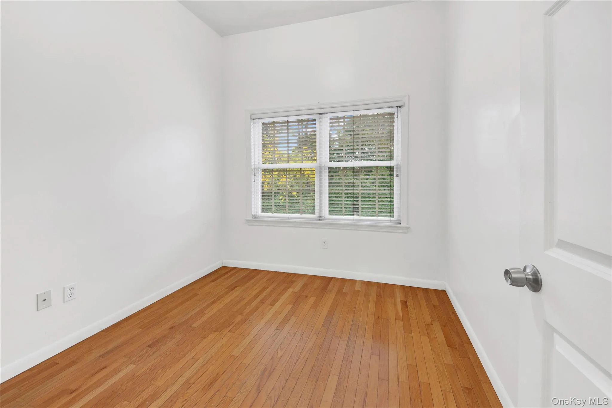 Empty room with baseboards and light wood-style floors Empty room with baseboards and light wood-style floors