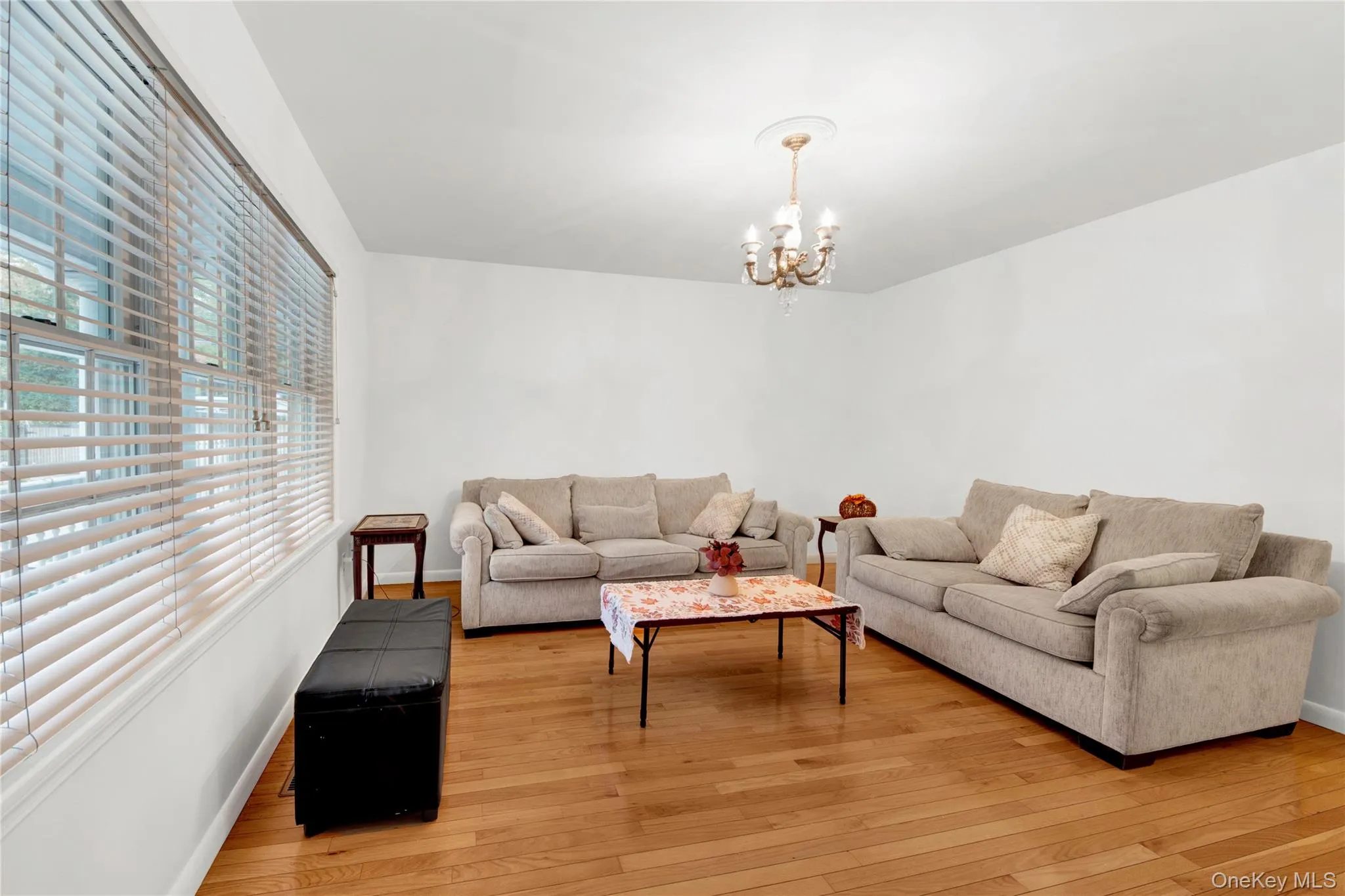 Living area with a chandelier and light wood-type flooring Living area with a chandelier and light wood-type flooring
