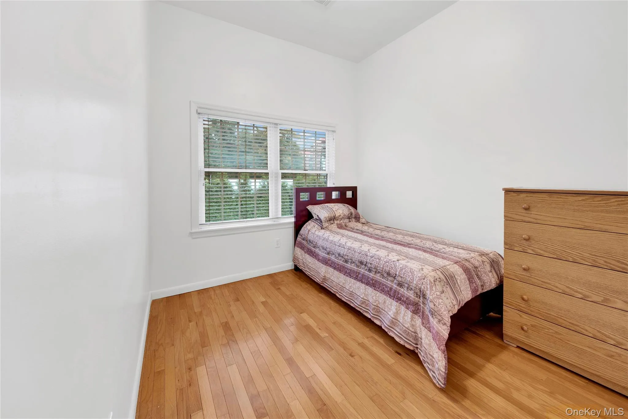 Bedroom with light wood-style flooring and baseboards Bedroom with light wood-style flooring and baseboards