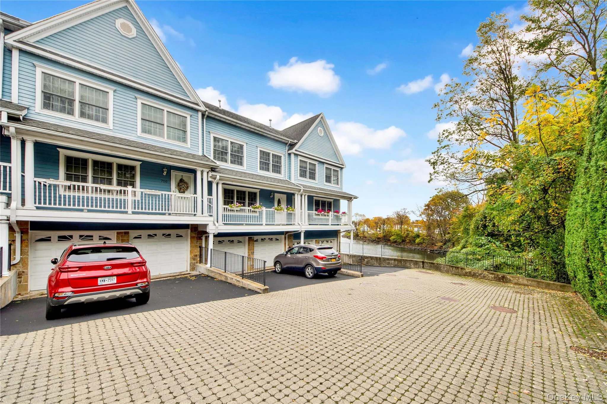 View of front of house with driveway, an attached garage, and a balcony View of front of house with driveway, an attached garage, and a balcony