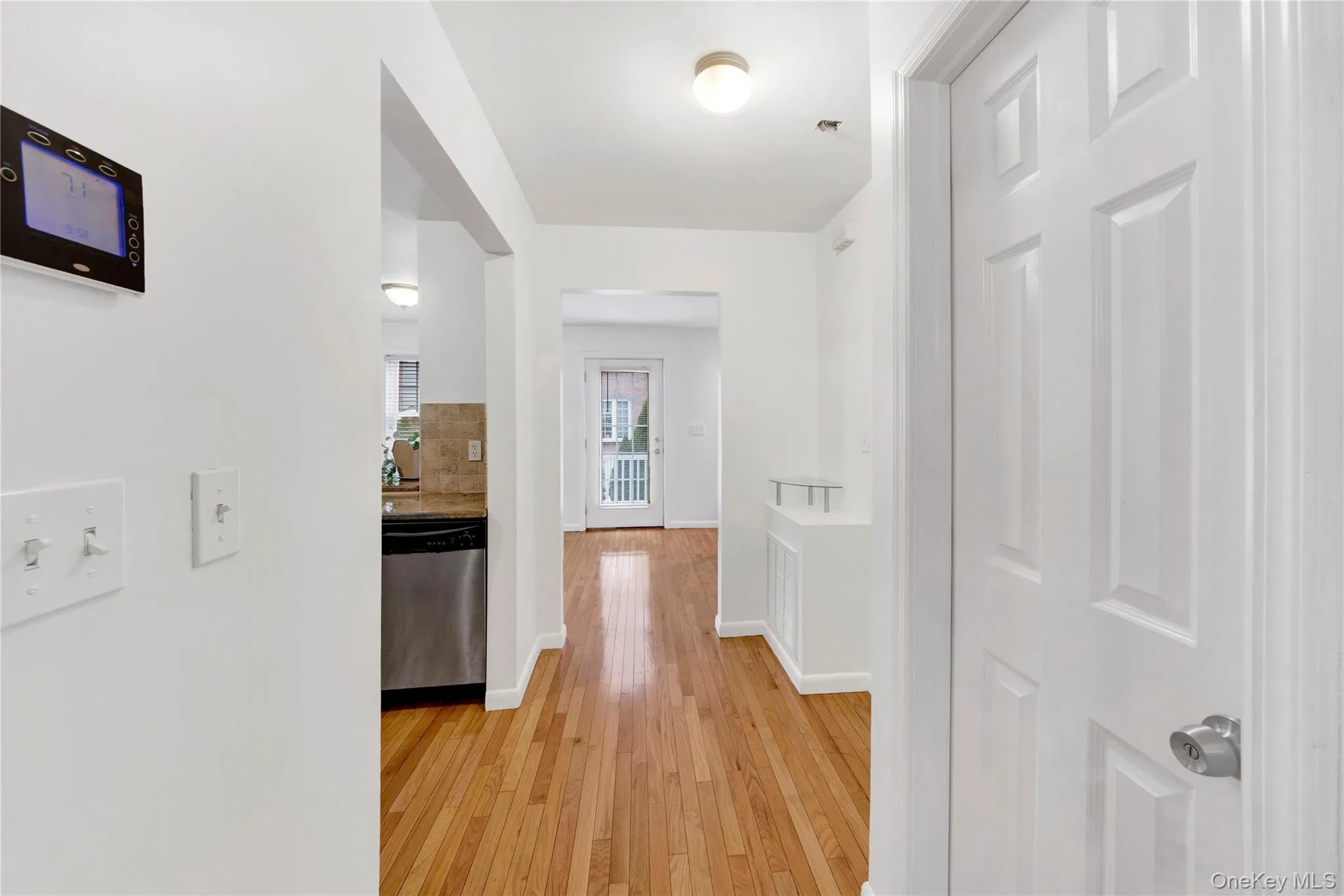 Hallway featuring light wood finished floors and baseboards Hallway featuring light wood finished floors and baseboards