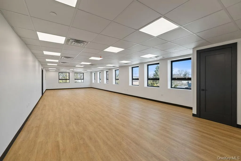 Empty room with a paneled ceiling and light wood-type flooring Empty room with a paneled ceiling and light wood-type flooring
