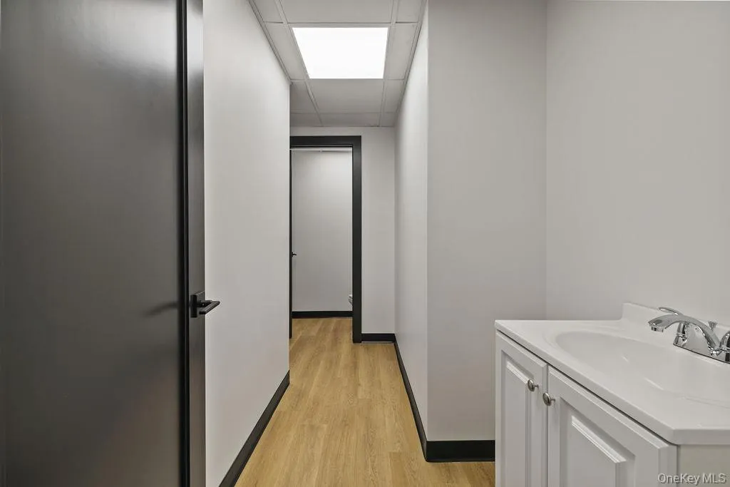 Bathroom featuring vanity, a paneled ceiling, and light wood-type flooring Bathroom featuring vanity, a paneled ceiling, and light wood-type flooring
