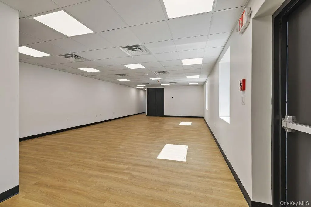 Empty room featuring light wood-style floors and a paneled ceiling Empty room featuring light wood-style floors and a paneled ceiling