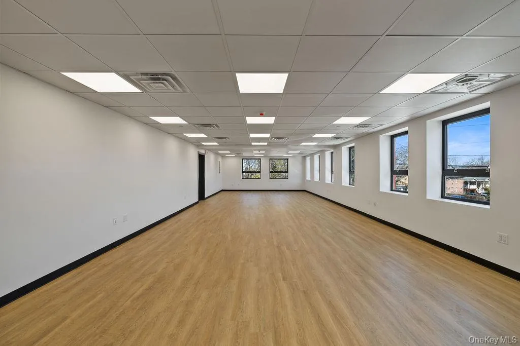 Empty room with a drop ceiling and light wood-type flooring Empty room with a drop ceiling and light wood-type flooring
