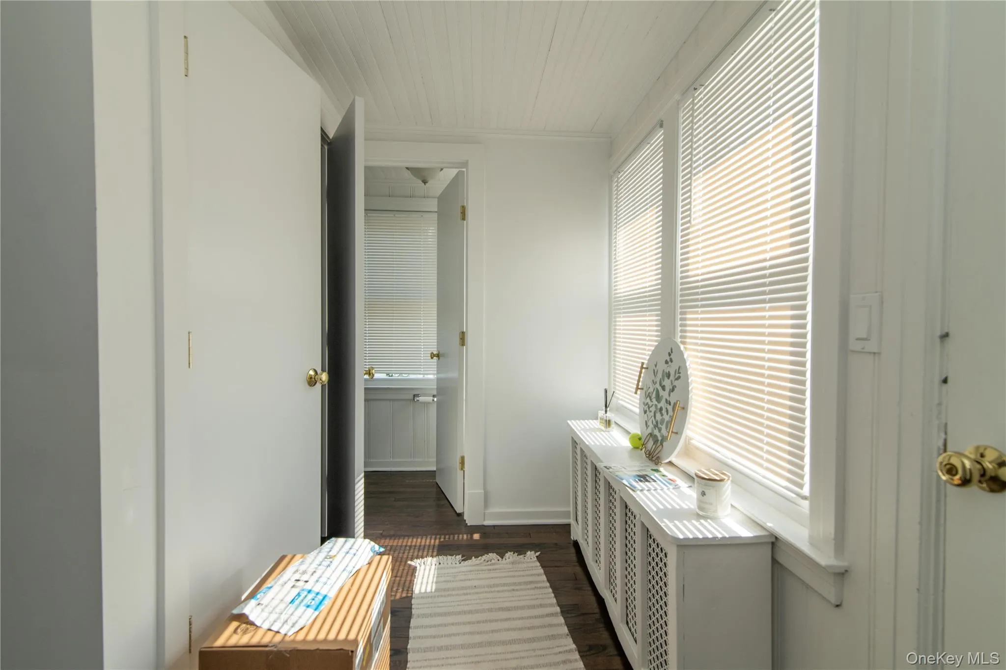 Corridor featuring dark wood-type flooring and baseboards Corridor featuring dark wood-type flooring and baseboards