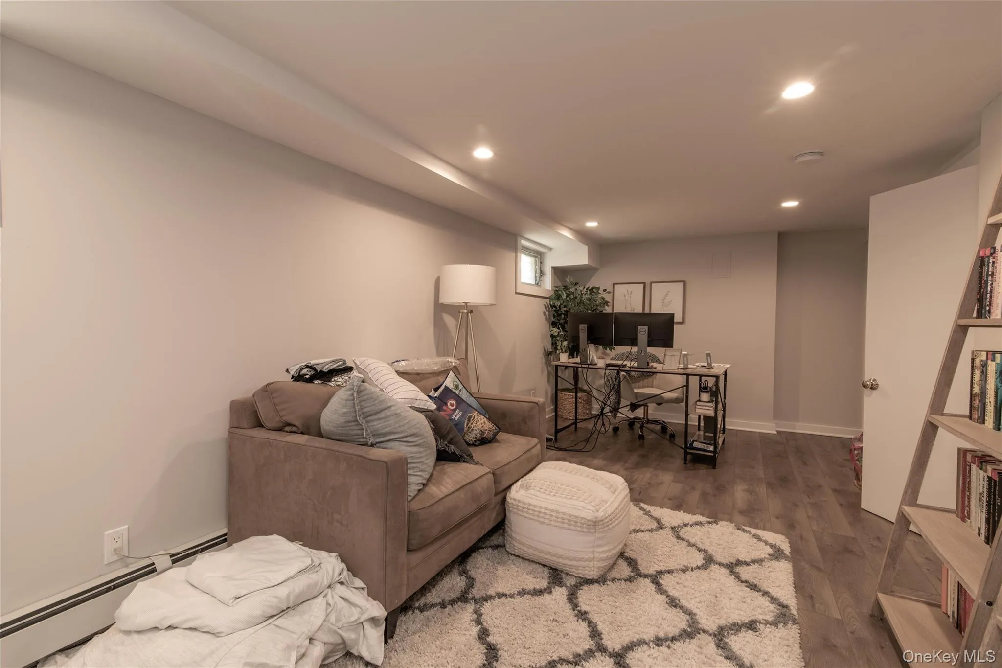 Living room with a desk, a baseboard radiator, recessed lighting, and wood finished floors Living room with a desk, a baseboard radiator, recessed lighting, and wood finished floors