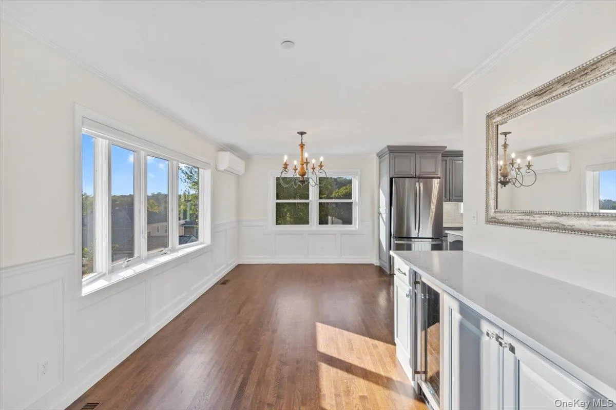 Entry and dining with a chandelier, a decorative wall, healthy amount of natural light, dark wood finished floors, and ornamental molding Entry and dining with a chandelier, a decorative wall, healthy amount of natural light, dark wood finished floors, and ornamental molding