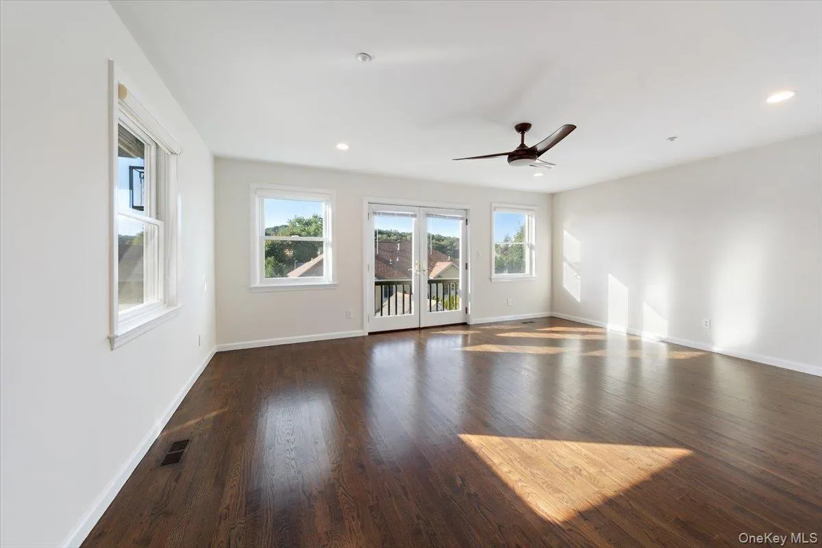 Empty room featuring dark wood finished floors, ceiling fan, french doors, and recessed lighting Empty room featuring dark wood finished floors, ceiling fan, french doors, and recessed lighting