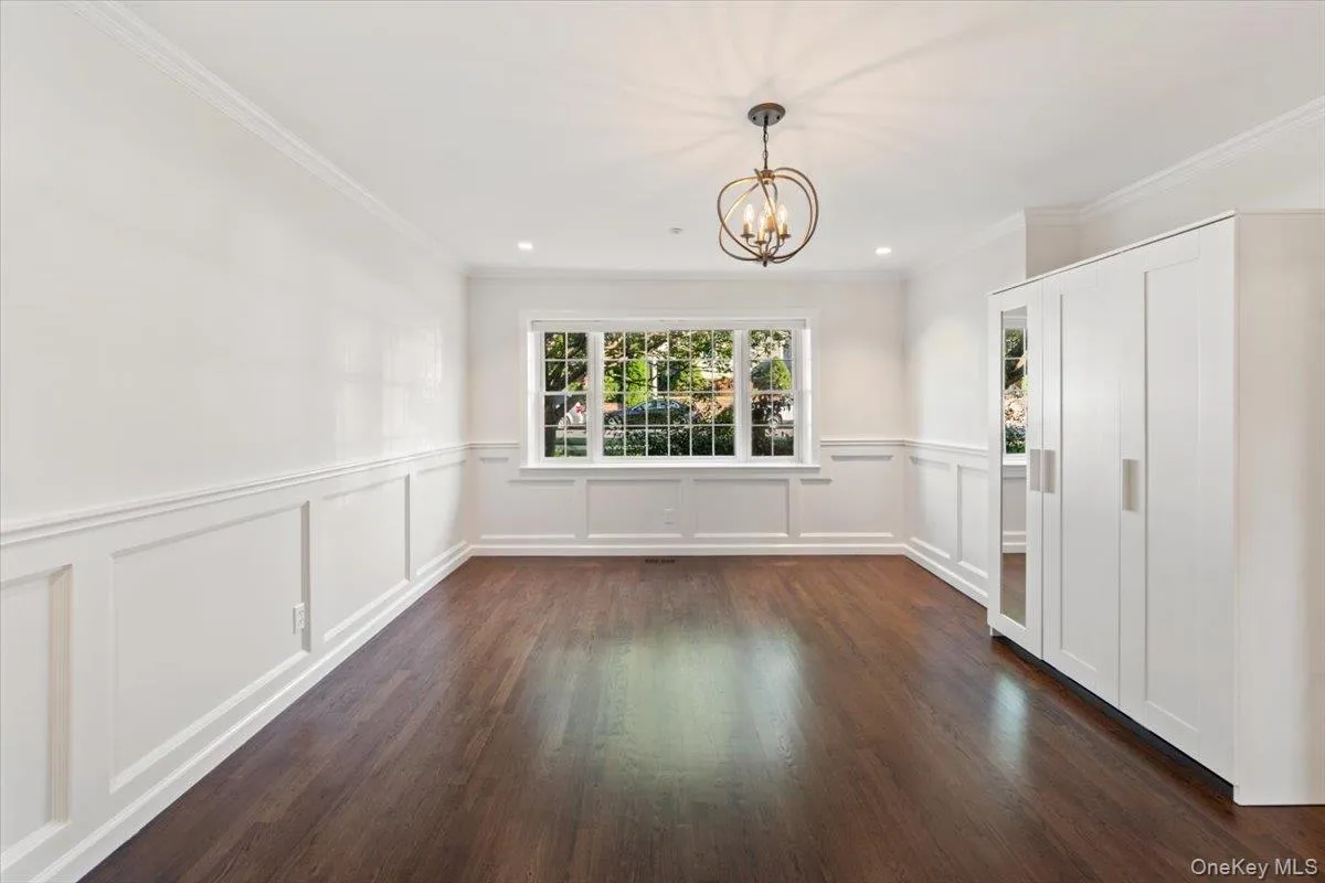 Unfurnished dining area featuring crown molding, a chandelier, dark wood-type flooring, and recessed lighting Unfurnished dining area featuring crown molding, a chandelier, dark wood-type flooring, and recessed lighting
