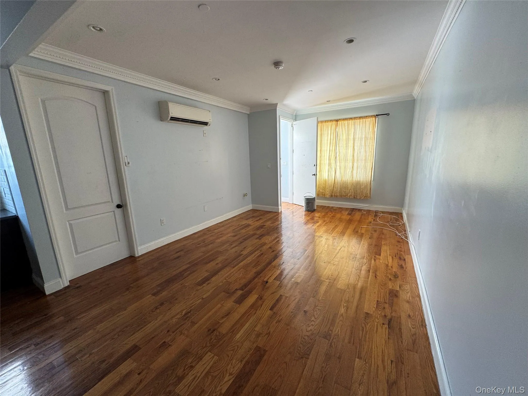 Spare room featuring dark wood-style floors and crown molding Spare room featuring dark wood-style floors and crown molding