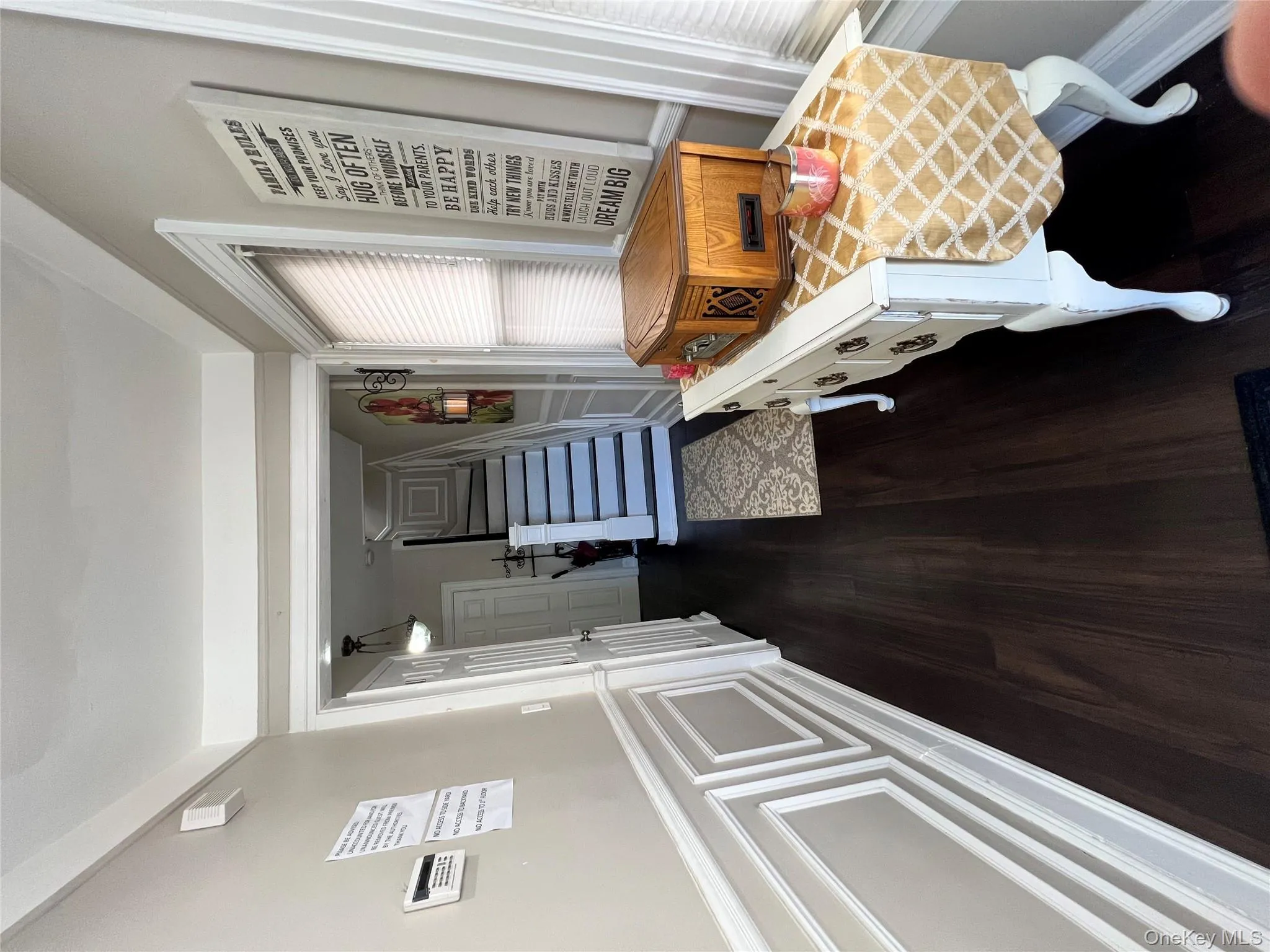 Corridor with dark wood-style flooring, a decorative wall, stairs, and a wainscoted wall Corridor with dark wood-style flooring, a decorative wall, stairs, and a wainscoted wall