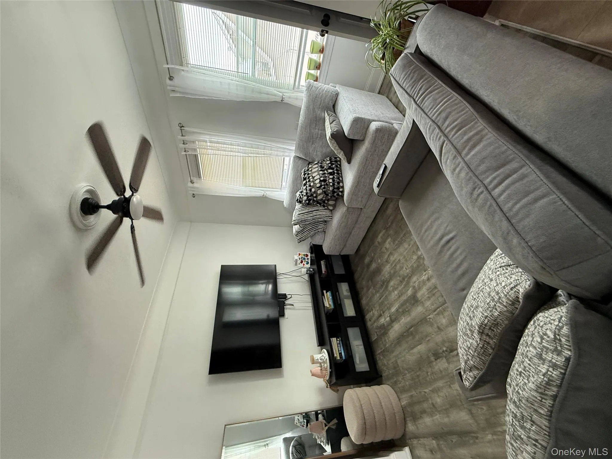 Living area with ceiling fan and wood finished floors Living area with ceiling fan and wood finished floors