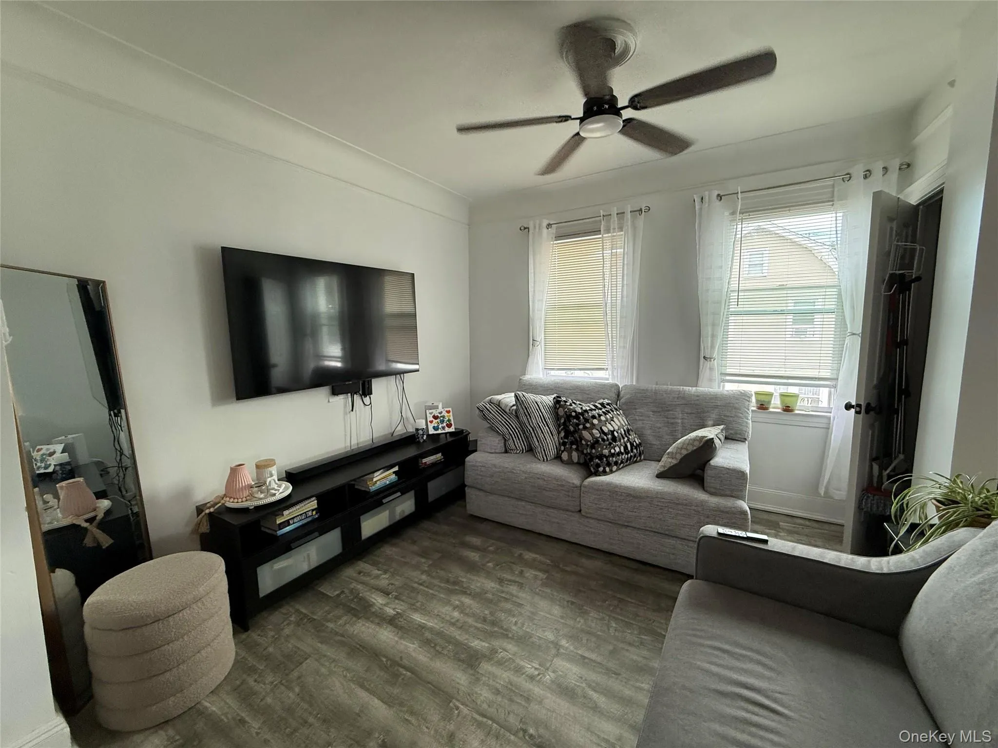 Living area featuring dark wood-style flooring and a ceiling fan Living area featuring dark wood-style flooring and a ceiling fan