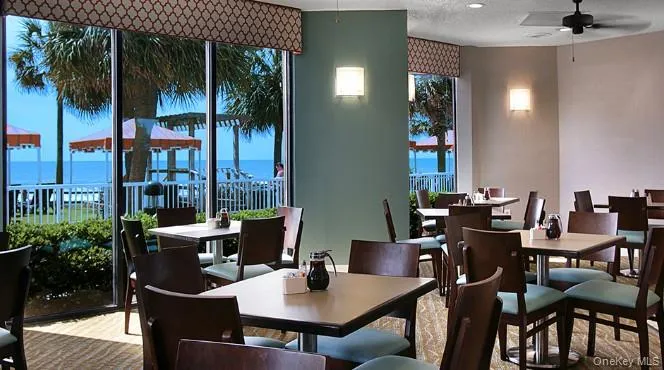 Dining room featuring a ceiling fan, a water view, and a textured ceiling Dining room featuring a ceiling fan, a water view, and a textured ceiling